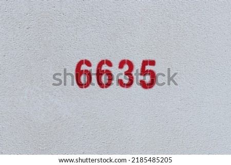 Red Number 6635 on the white wall. Spray paint.
