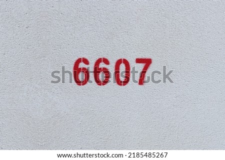 Red Number 6607 on the white wall. Spray paint.
