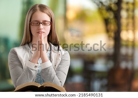 Hands folded in prayer on a Holy Bible in church for faith, spirituality and religion