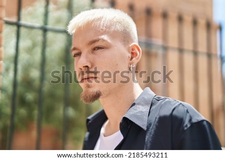 Young caucasian man standing with serious expression at street