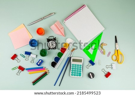 Back to school concept. Colorful school or office supplies on green table. Flat lay, top view, copy space.