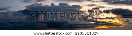 Panorama sunset sky and dark clouds.Fluffy cloud in the black sky background.Vivid sky on dark cloud before summer storm. Royalty-Free Stock Photo #2185511329