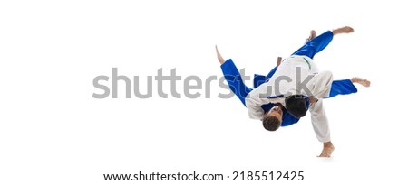 Studio shot of two men, professional judo athletes training isolated over white background. Sweeping hip throw. Concept of martial art, combat sport, health, strength, energy. Copy space for ad, flyer Royalty-Free Stock Photo #2185512425