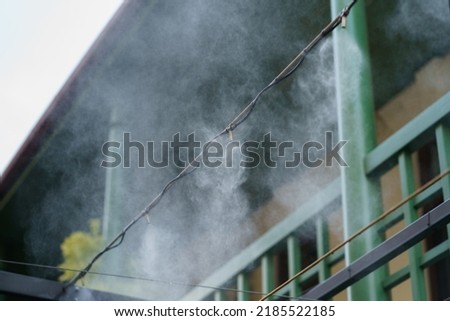 Air conditioning and water spray system for cooling and fog. Fogging system for outdoor cafe terraces. Humidify, cooling and cleaning air from dust in hot day. Air humidification for plants in Royalty-Free Stock Photo #2185522185