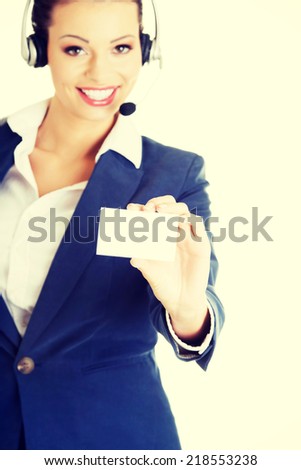 Smiling customer service representative with headset holding a blank empty businesscard. Isolated on white background.