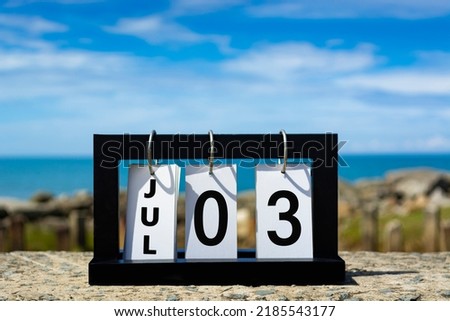 Jul 03 calendar date text on wooden frame with blurred background of ocean. Calendar date concept.