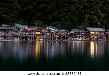 Traditional wooden boathouses reflect of calm water as night falls on Ine, Kyoto Royalty-Free Stock Photo #2185550485