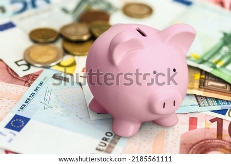 Classic Piggy Bank and money on the desk Royalty-Free Stock Photo #2185561111