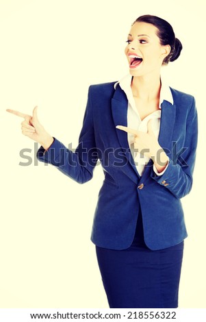 Happy young business woman pointing on copy space, isolated on white