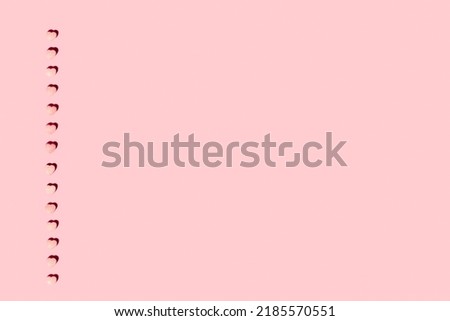 Pink heart shape candies on a pink background with copy space
