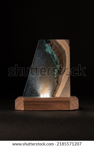 Night LED lamp made of wood and epoxy resin. Vintage lighting for a bedroom or hallway. Dark background for New Year or invitation cards. Christmas or Silvester day decoration layer. 
