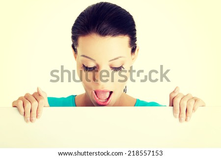 Shocked woman holding blank board, isolated on white