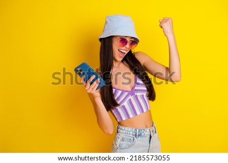 Photo of adorable girl celebrate giveaway victory win clothes from online shop isolated on yellow color background Royalty-Free Stock Photo #2185573055