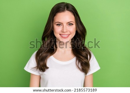 Photo of adorable cute young lady wear white t-shirt smiling isolated green color background