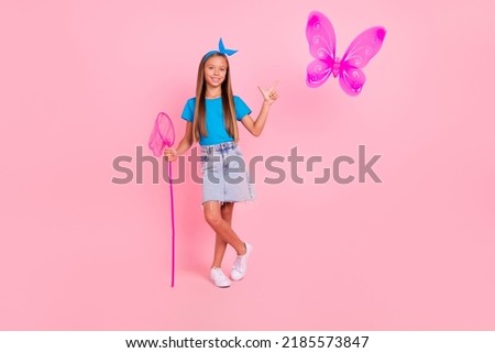 Full length photo of cheerful charming person hand hold net direct finger butterfly isolated on pink color background