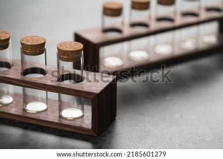 empty walnut holder with glass tubes for spices on concrete surface, shallow focus