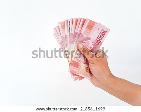 Man's Hand showing rupiah money isolates on white background Royalty-Free Stock Photo #2185611699