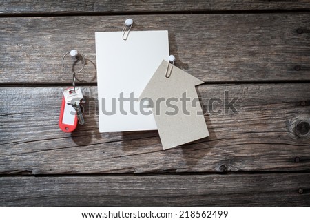 paper and keys on wooden background 