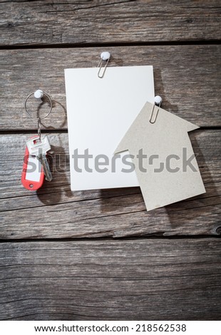 paper and keys on wooden background 