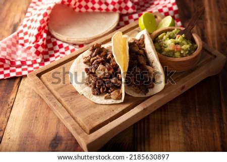 Tacos de Bistec. Homemade grilled meat in a corn tortilla. Street food from Mexico, traditionally accompanied with cilantro, onion and spicy sauce or guacamole