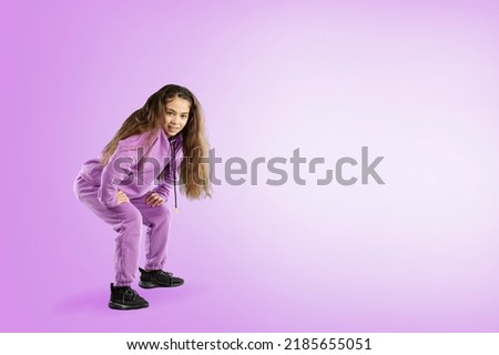 Overjoyed teen girl in fashionable clothes dance on studio background. Hobby and entertainment.
