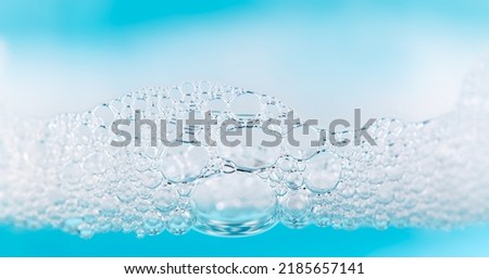 Foam. Soap foam popping bubbles background. Soap sud macro structure. Soap foam close-up, blue background 