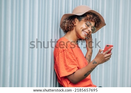 hipster girl with mobile phone and hat on the street