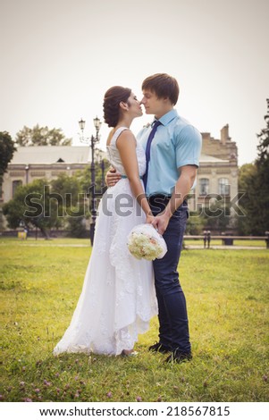 Beautiful couple in love. Wedding day. Wedding dress. Tiffany blue and white colors. Bouquet of roses. Park outdoors