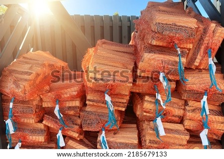 Firewood in the grid. Big pile of firewood packed in nets for sale
