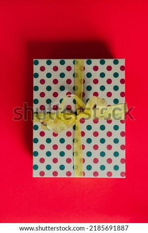 Christmas gift box, present with golden ribbon. Top view of Christmas gift on red background. Merry Christmas. Winter holidays, New Year, birthday presents. Seasons greetings copy space for text