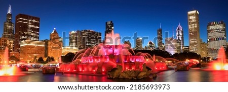 Chicago skyline illuminated at dusk with colorful Buckingham fountain on the foreground, Illinois, USA
