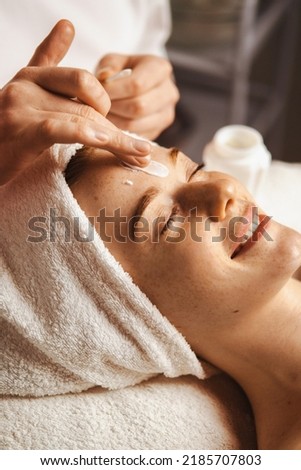Close-up portrait of woman getting spa facial massage treatment with moisturising cream at beauty spa salon. Natural skin care cosmetic. Health care, beauty Royalty-Free Stock Photo #2185707803