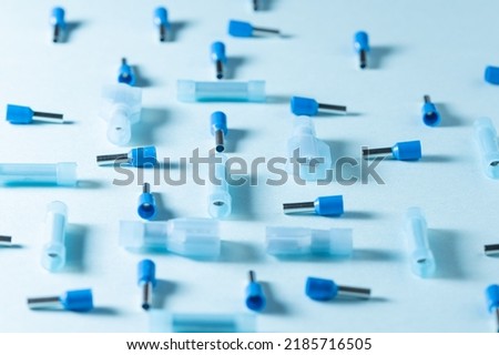 Closeup photo of blue electrical cable connectors of different types over a blue surface.