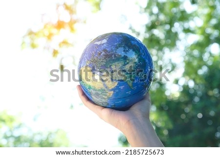 man's hand holding a globe, showing the world's healing, protecting the planet from global warming.