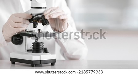 Scientist using microscope in laboratory Royalty-Free Stock Photo #2185779933