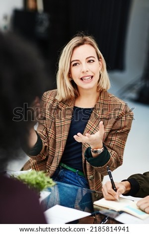 Creative woman talking in business meeting, discussing and explaining with team of employees in office. Stylish designer chatting about future project, idea or strategy looking dedicated and focused Royalty-Free Stock Photo #2185814941