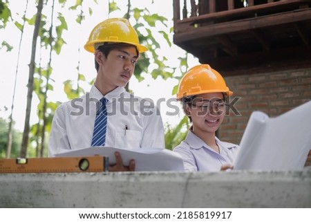 Team of male and female engineers and architects, working team, meeting, discussing construction, and inspecting the outdoor construction site work.