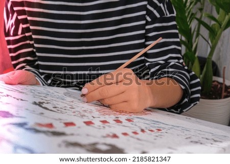 Female hands coloring canvas Picture by numbers Creative hobby. Painting for beginners. Leisure activity for stay home lockdown, anti-stress idea. Meditation, relax concept. Mindfulness acivity