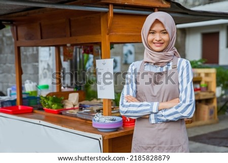 proud young muslim woman standing in front of her small traditional food shop Royalty-Free Stock Photo #2185828879