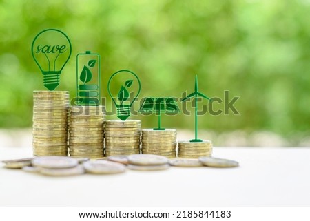Alternative or renewable energy financing program, financial concept : Green eco-friendly or sustainable energy symbols atop five coin stacks e.g a light bulb, a rechargeable battery, solar cell panel Royalty-Free Stock Photo #2185844183