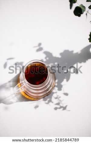 fresh hot filter coffee in a glass server, standing in the summer shadows on the white table vertical image, top view, flat lay Royalty-Free Stock Photo #2185844789