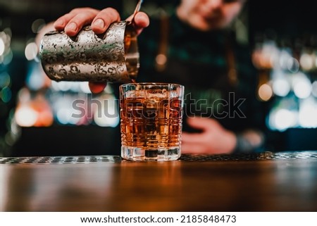man bartender hand making negroni cocktail. Negroni classic cocktail and gin short drink with sweet vermouth, red bitter liqueur Royalty-Free Stock Photo #2185848473