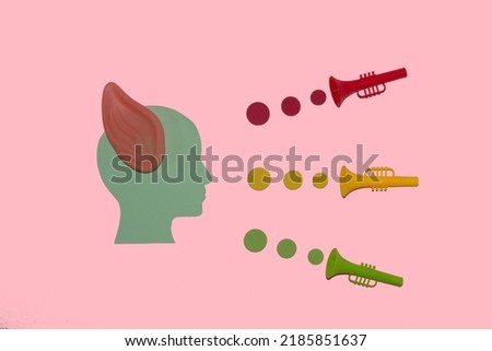 paper head with ear listens colorful trumpet, creative art design, pink background