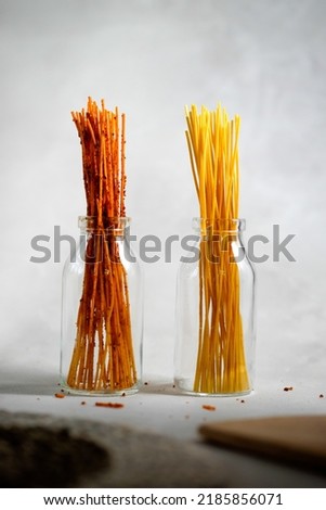 Indonesian Snacks Spicy and Salty Long Sticks on the Glass Bottle Royalty-Free Stock Photo #2185856071