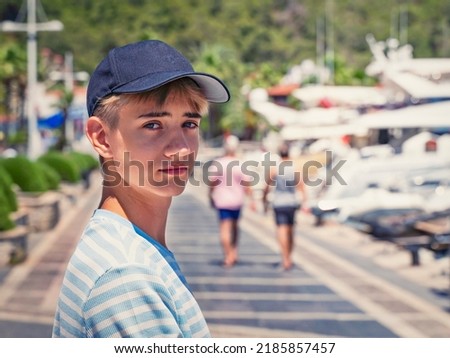 handsome teenager wearing a black blank baseball cap with space for your logo or design
