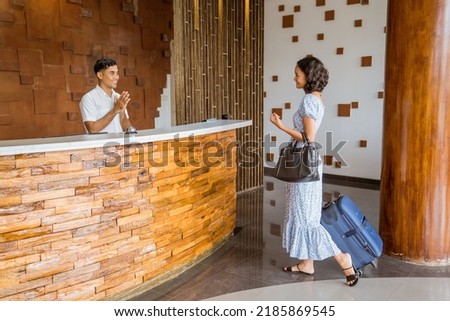 Female guests come with bags and suitcases to the hotel reception in the lobby Royalty-Free Stock Photo #2185869545
