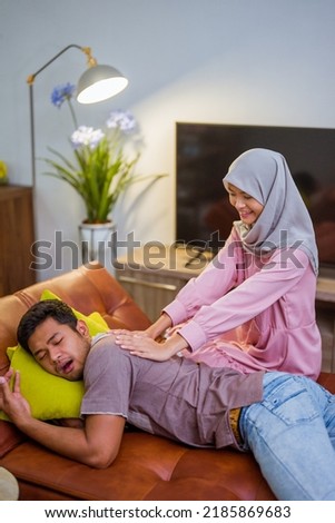 muslim wife waking her husband up in the bed to have a breakfast for fasting during day of ramadan month Royalty-Free Stock Photo #2185869683