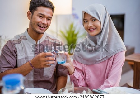 excited couple hearing adhan voices that mean iftar time or the for breaking the fast Royalty-Free Stock Photo #2185869877