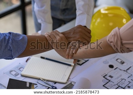 Architect engineers shake hands with hats and houses on construction tool tables. with blueprints on the table - business teamwork working together Successful Collaboration Ideas