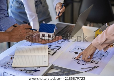 Engineer and architect team meeting with helmet and house on construction tool table With blueprints on the table - successful business collaboration. successful cooperation concept